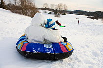 Young girls sledding at Wagon Hill Farm in Durham, New Hampshire, USA, January 2009.