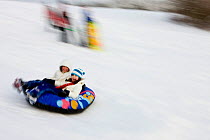 Young girls sledding at Wagon Hill Farm in Durham, New Hampshire, USA, January 2009. Model released.