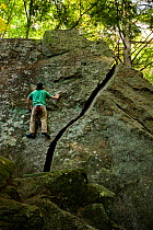 Man bouldering in "The Boulders" section of Pawtuckaway State Park, New Hampshire, USA, September 2008.