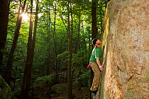 Man bouldering in "The Boulders" section of Pawtuckaway State Park, New Hampshire, USA, September 2008. Model released.