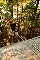 Man rappelling over Lower Slab in Pawtuckaway State Park, New Hampshire, USA, September 2008. Model released.