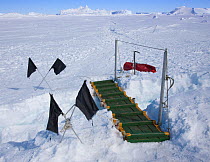A bridge to cross a lead in the sea ice (with crossed flags to mark hazard) near Snow Hill Island, Weddell Sea, Antarctica November 2009