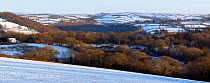 Snow covered patchwork of fields and woodland in West Wales, UK