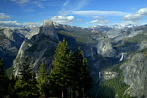 Cumulus and cirrus clouds in blue sky above east side of Yosemite Valley and Clark range including Half Dome, Liberty Cap, Vernal and Nevada falls, Sierra Nevada Mountains, Yosemite National Park, Cal...