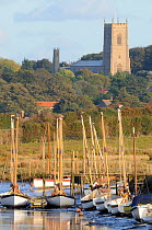 Boats in Morston harbour, with Blakeney Church in distance, North Norfolk, UK, October 2009