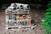 "Insect Home" in a garden. Created with pallets, bricks, pots, stones, bark and piping. Used by insects such as ladybirds, bees and lacewings and amphibians to hibernate over winter. Sussex, England,...