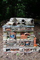 "Insect Home" in a garden. Created with pallets, bricks, pots, stones, bark and piping. Used by insects such as ladybirds, bees and lacewings and amphibians to hibernate over winter. Sussex, England,...