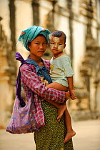 Mother and boy with Thanakha painted on face. Bagan, Mandalay State, Myanmar (Burma). September 2009