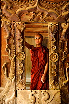 Buddhist monk inside teakwood monastery. Bagan, Mandalay State, Myanmar (Burma). September 2009