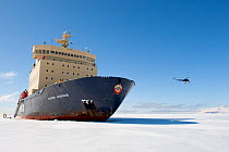 People disembarking from a Russian ice breaker ship, Kapitan Khlebnikov, amongst sea ice on a Quark expedition, Helipcopter flying in background, Ross Sea, Antarctica, November 2008