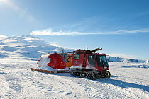 Tracked vehicle towing a hut and gas cylinder to ice hole for the BBC film crew, Piston Bully, Ross Sea, McMurdo Sound, Antarctica, November 2008
