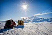 Dive hut and track vehicle for BBC film crew, McMurdo, Ross Sea, Antarctica,  Mt Erebus in the background, November 2008