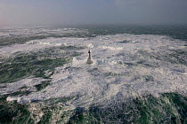 Waves crashing around Ar-Men Lighthouse (37 metres) in the Sein channel, Finistère, Brittany, France. December 2007.