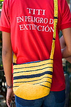 Colombian woman wears a "tamarins in danger of extinction" t-shirt and an eco-mochila (bag) woven from recycled plastic bags. Los Limites, Colombia, South America. February 2008