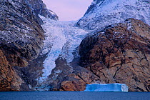 Glacier descending into the narrow fjord, which is almost 50 nautical miles long, 4 to 5 nautical miles wide, and 1000 meters (more than 3200 feet) deep. Ofjord, within Scoresby Sund, Greenland