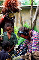 Huli people looking at camera equipment with Huw Cordey, producer for Jungles episode of BBC series Planet Earth, Tari Valley, Papua New Guinea, August 2004.