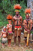 Huli wigmen and children in traditional clothing, feather headdress and weapons. Tari Valley, Papua New Guinea, during filming of BBC series Planet Earth, August 2004.