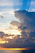 Crepuscular rays from behind a cloud at sunset in the Exumas, Bahamas, Caribbean. June 2009.