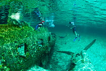 Boys exploring plane wreckage in Exumas, Bahamas, Caribbean. June 2009, model released.