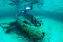 Young man exploring plane wreckage in Exumas, Bahamas, Caribbean. June 2009, model released.