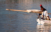 Men working with the long boom of a Bahamian Sloop at the Bahamian Sloop regatta, Georgetown, Exumas, Bahamas. April 2009.