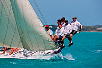Crew riding the pry (hiking board/plank) during the Bahamian Sloop regatta, Georgetown, Exumas, Bahamas. April 2009.