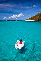 Inflatable tender towed behind a yacht in the Grenadines, Caribbean. February 2010.