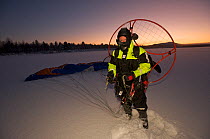 Dan Burton, photographer, with his motorised paraglider that enables him to fly at 30ft to photograph the reindeer being rounded up in Lapland, Sweden, November 2009