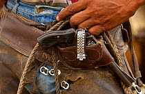 Pantanal cowboys 'Boiadeiro' often decorate their clothing and horses and tack with pieces of metal. This cowboy has soda can tops on his chaps and an old watch strap secures his pistol in place. Mato...