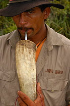 Portrait of Pantanal 'Boiadeiro' cowboy ('Ado' Gilson Gomez) drinkng 'hierba de mate' from a hollowed out bull's horn. Mato Grosso do Sul Province. Brazil, South America December 2004