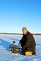 Cameraman Keith Brust filming with Red Camera, in snow covered landscape, Minnesota, USA, March 2008