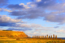 Giant moai statues in Ahu Tongariki at sunset, with Poike cliffs and Motu Marotiri islet in the background, Easter Island, Pacific ocean, November 2004