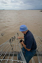 Fisherman removing seaweed from putcher baskets. These baskets are used as a traditional method to catch Atlantic salmon. This way of life is potentially threatened by proposed tidal barrage. River Se...