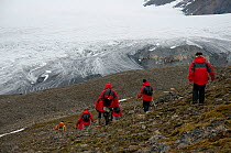 Cruise ship tourists hiking to Osbornebreen, a retreating glacier in St. Jonsfjord, west coast of Svalbard, Norway. July 2009
