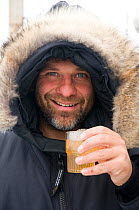 Photographer Steven Kazlowski enjoys a scotch after a long day, during an expedition to photograph wildlife in Svalbard, Norway. August 2009