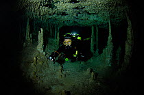 Diver exploring a freshwater Limestone sinkhole / Cenote a traverse to 'The White River' with stalactites and stalagmites, Tulum, Quintana Roo, Mexico, September 2008