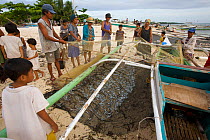 Villagers at Malapascua Island meet returning fishing boats at dawn and help collect the tiny fish from the nets. This seems to be all the fisherman are catching in this heavily overfished area.   Vis...