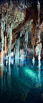 Stalagmites and stalactites in underground cavern with azure waters of Cenote Papakal (sink hole), near Merida, Yucatan, Mexico October 2009