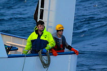 Trawler crew on stern looking behind. North Sea, July 2010.