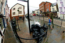 Uncollected council waste bags from businesses, in the streets of a small town. Wales, UK July 2008