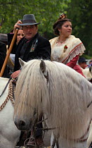 Portrait of a young Gardian (traditional French cowboy) riding a Camargue horse with very long white mane during the Fete des Gardians (Gardians' Festival), in Arles, Provence, Camargue, France. May 2...