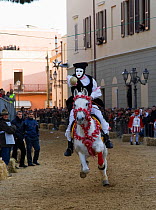 A performing masked rider on a horse (Equus caballus) from the Gremio dei Contadini tries to catch the star during the 'Sartiglia' (race to the star) in Oristano, Sardinia, Italy. February 2010