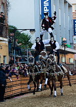 Horses (Equus caballus) and riders from the Gremio dei Contadini performing acrobatics for the gathered crowds, after the 'Sartiglia' (race to the star) in Oristano, Sardinia, Italy. February 2010