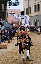 'Su Componidori' (head of the race) masked rider on a horse (Equus caballus) from the Gremio di Falegnami catches the star of 'Sartiglia' (race to the star) in Oristano, Sardinia, Italy. February 2010