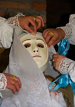 During the dressing of the Gremio di Falegnami, 'Su Cumponidori' the head of the 'Sartiglia' (race to the star) is officially dressed in the traditional costume and mask  in Oristano, Sardinia, Italy....