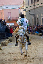 'Su Cumponidoreddu' the performing masked rider on a horse (Equus caballus) and the head of the 'Sartiglia' (race to the star), tries to catch the star, in Oristano, Sardinia, Italy. February 2010