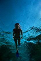 Snorkeler exploring blue water above coral reef, Sinai, Egypt, Red Sea Model released Model released.