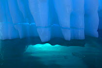 Iceberg detail with light coming through opening underwater, Antarctica, February
