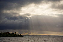 Sunbeams shining through clouds onto the lagoon of Fakarava Atoll, Tuamotu Islands, French Polynesia. July 2006