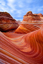 Sensationally twisted sandstone curves of Arizona's famous wave formation seen under partly cloudy skies. Vermilion Cliffs, Arizona, USA, December 2007.